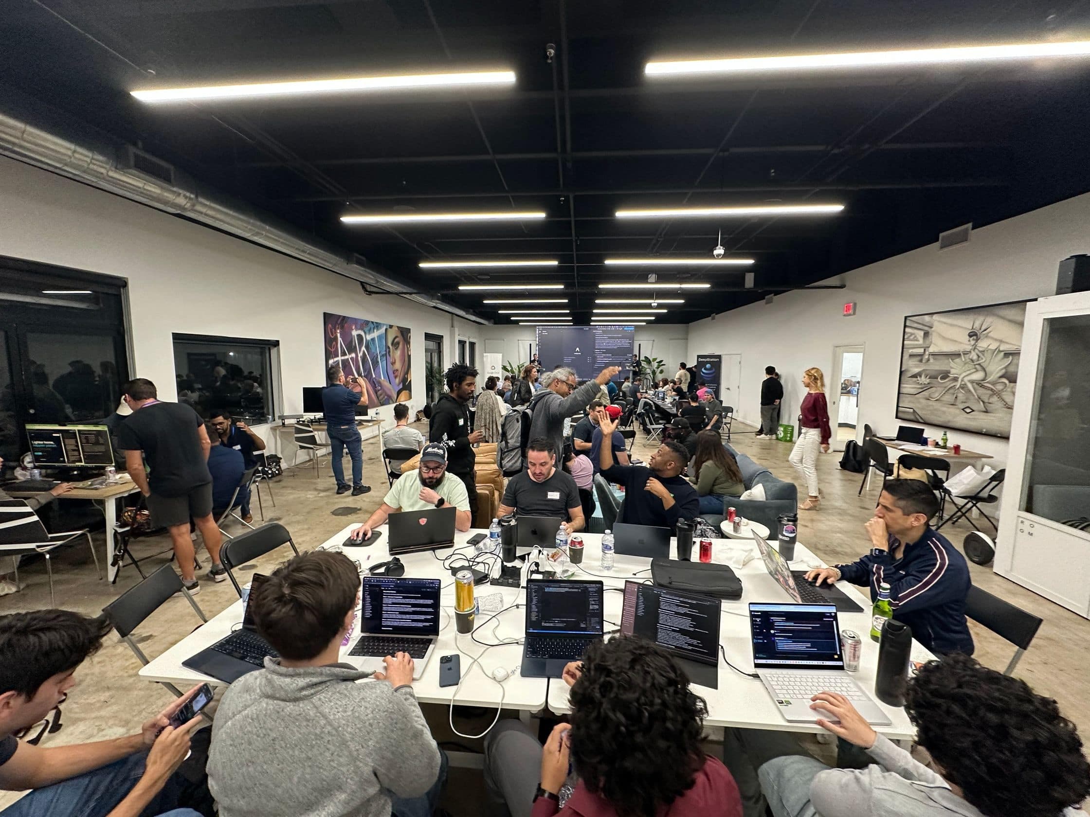 Teams build at shared tables during the Google Hackathon in Miami